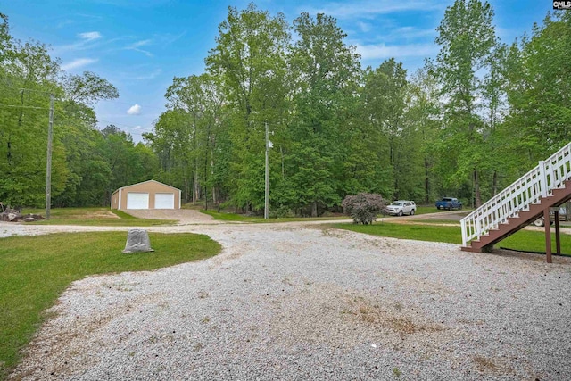 view of street with gravel driveway, stairway, and a forest view
