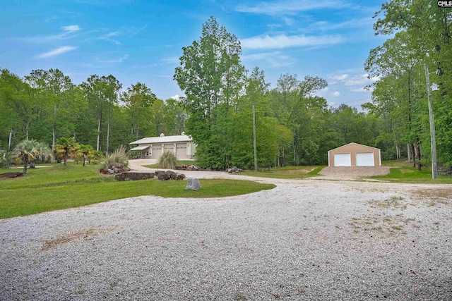 surrounding community featuring a garage, a yard, and a forest view