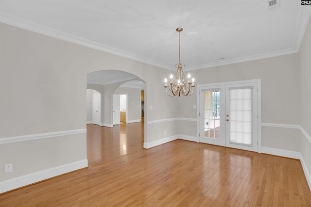 unfurnished dining area with visible vents, light wood-style floors, baseboards, arched walkways, and a notable chandelier