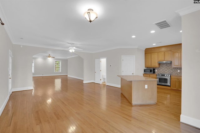 kitchen featuring visible vents, a kitchen island, ceiling fan, under cabinet range hood, and stainless steel appliances