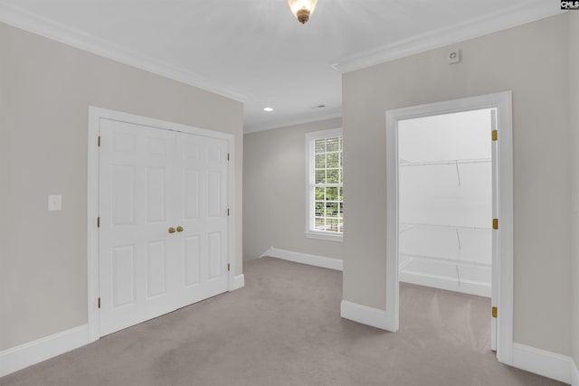 unfurnished bedroom featuring baseboards, ornamental molding, a closet, and carpet flooring