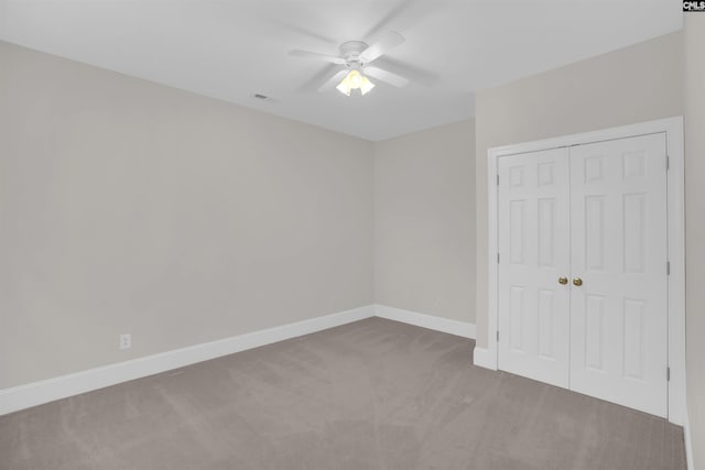 unfurnished bedroom featuring ceiling fan, carpet floors, baseboards, visible vents, and a closet