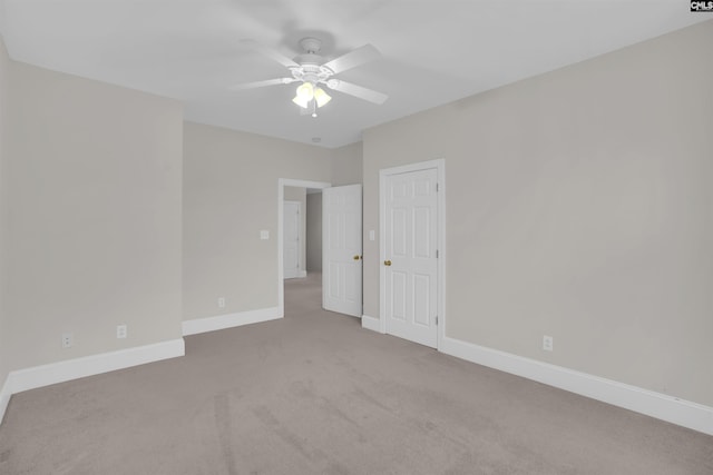 empty room featuring baseboards, carpet flooring, and ceiling fan