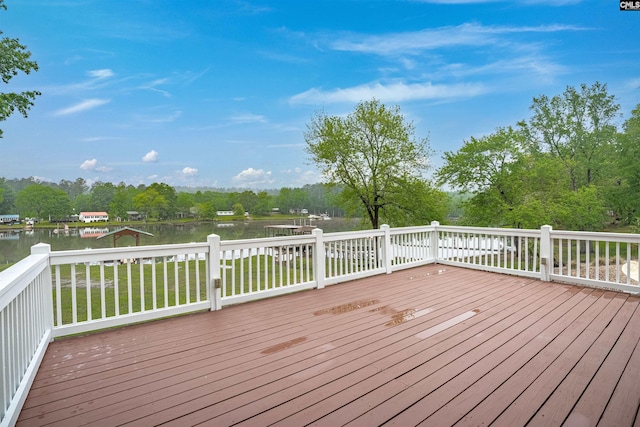 wooden terrace with a lawn and a water view