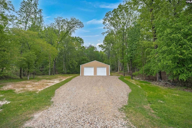 detached garage with a view of trees