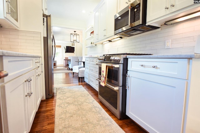 kitchen featuring dark wood-style flooring, light countertops, white cabinetry, backsplash, and stainless steel appliances