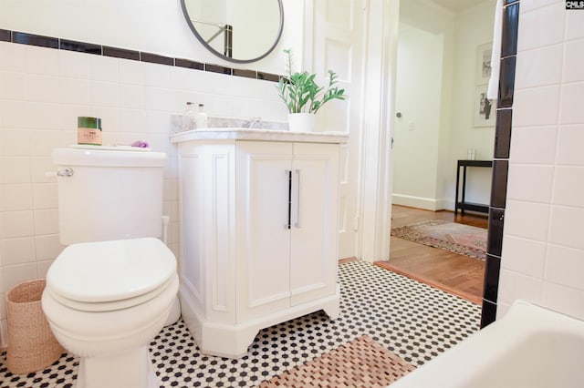 bathroom featuring tile walls, vanity, and toilet