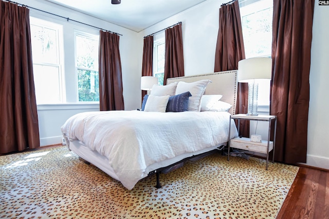 bedroom featuring baseboards and wood finished floors