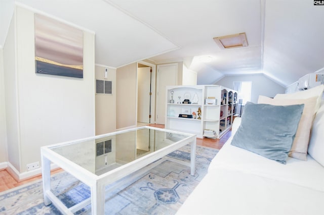 bedroom with attic access, vaulted ceiling, visible vents, and light wood finished floors
