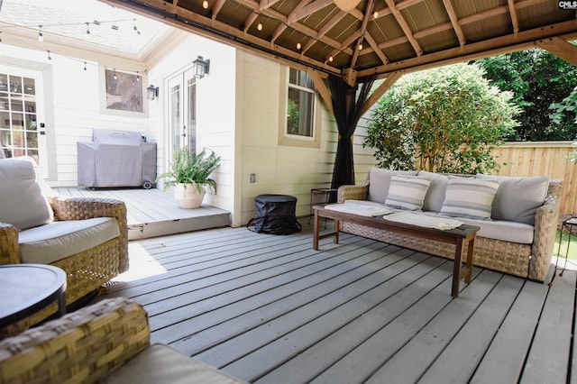 wooden terrace featuring a gazebo, fence, and an outdoor hangout area