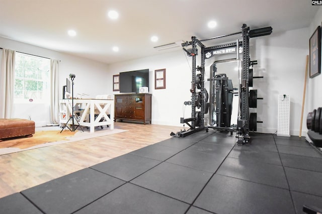 workout room featuring recessed lighting, baseboards, and wood finished floors