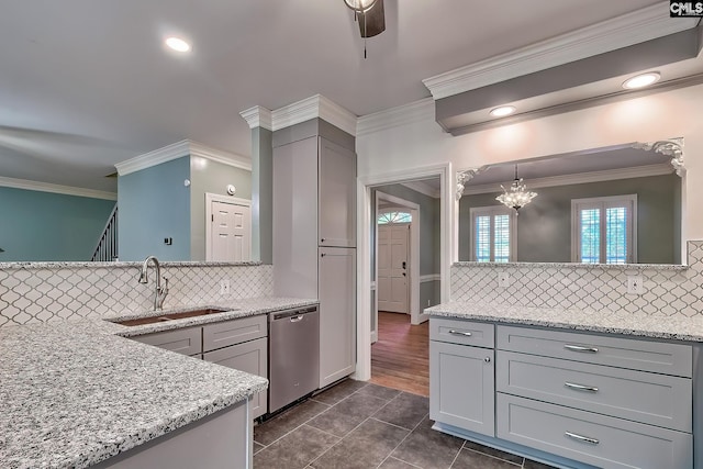 kitchen with crown molding, decorative backsplash, a sink, dishwasher, and gray cabinetry