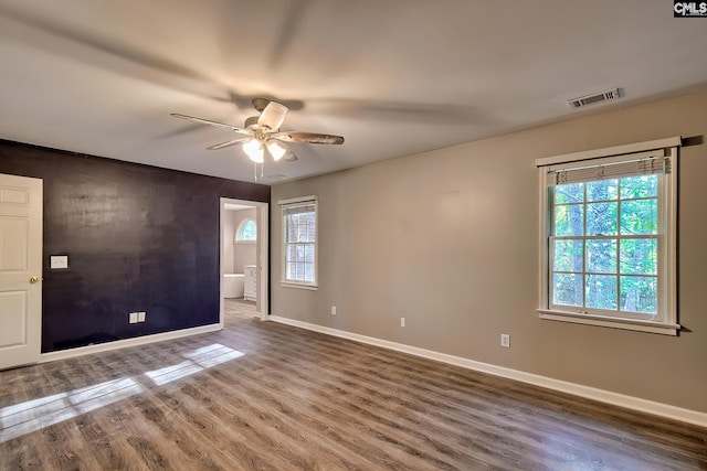 empty room with baseboards, ceiling fan, and wood finished floors