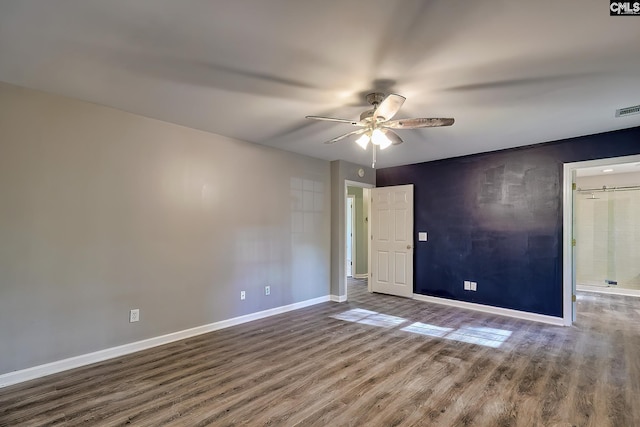 unfurnished room featuring baseboards, a ceiling fan, wood finished floors, and visible vents