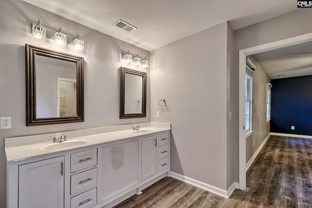 full bathroom featuring visible vents, a sink, wood finished floors, and double vanity