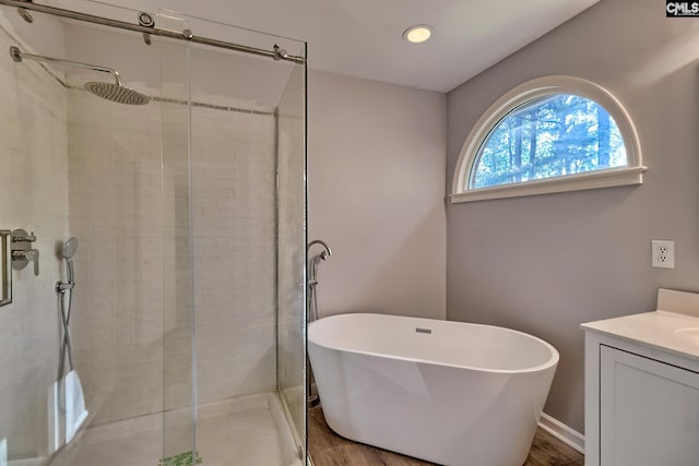 bathroom featuring vanity, recessed lighting, a freestanding bath, and a shower stall