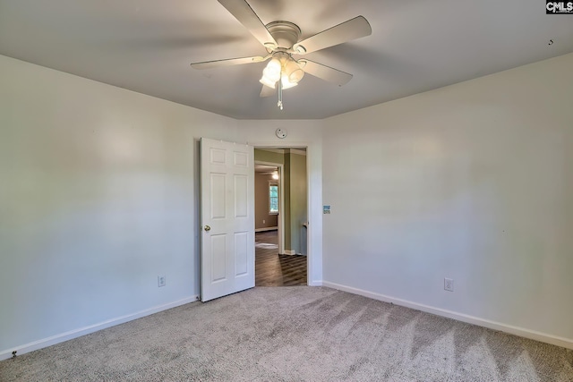 carpeted spare room with baseboards and a ceiling fan