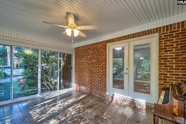 unfurnished sunroom featuring a ceiling fan and french doors