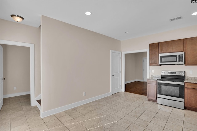 kitchen featuring baseboards, appliances with stainless steel finishes, light tile patterned floors, and visible vents