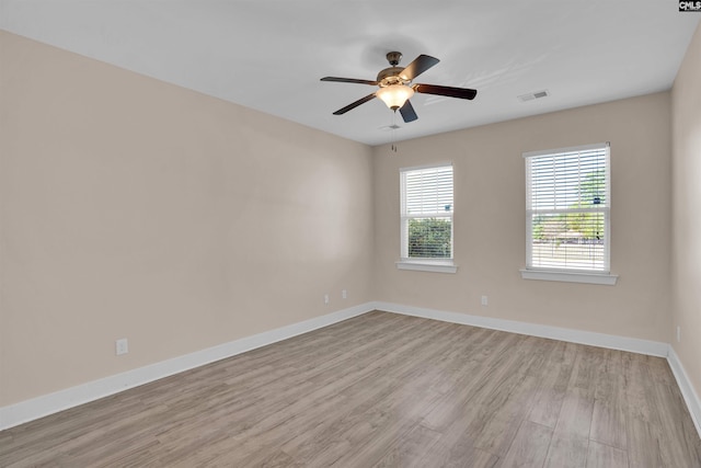 empty room with ceiling fan, baseboards, visible vents, and light wood-style flooring