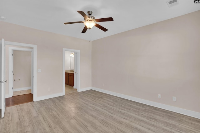 unfurnished bedroom featuring a ceiling fan, baseboards, visible vents, and light wood-style floors