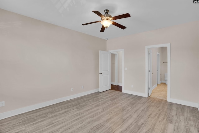 unfurnished bedroom with connected bathroom, baseboards, ceiling fan, and light wood-type flooring