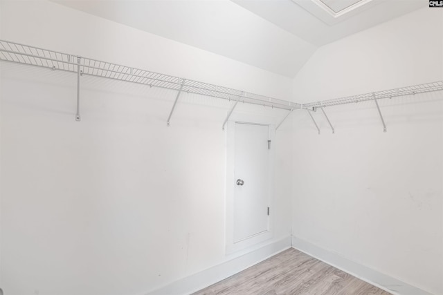 spacious closet with light wood-style flooring and lofted ceiling