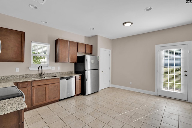 kitchen with a sink, stainless steel appliances, baseboards, recessed lighting, and light tile patterned floors