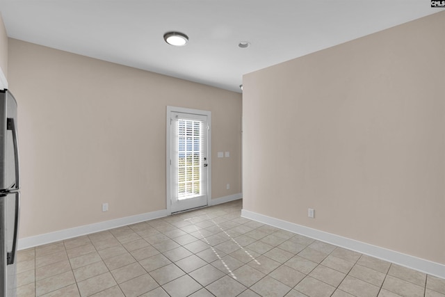 unfurnished room featuring baseboards and light tile patterned flooring