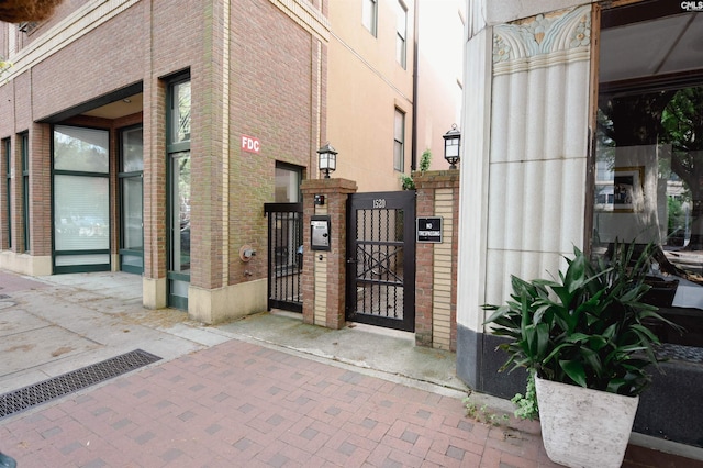 exterior space with a gate and brick siding