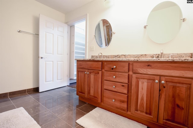 full bath with baseboards, double vanity, and a sink