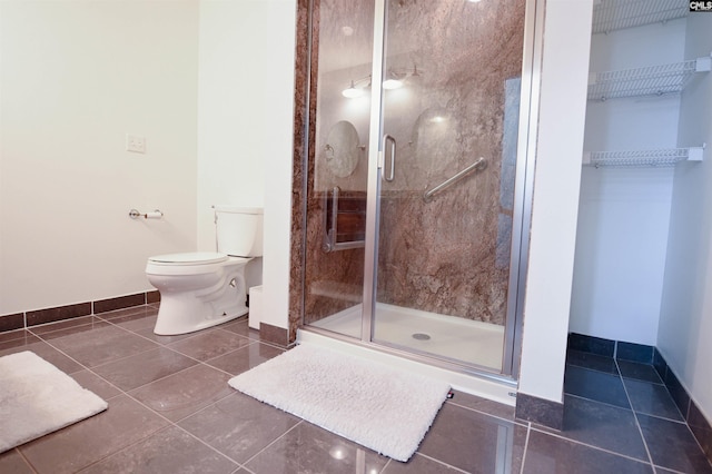 full bathroom with toilet, tile patterned floors, baseboards, and a stall shower