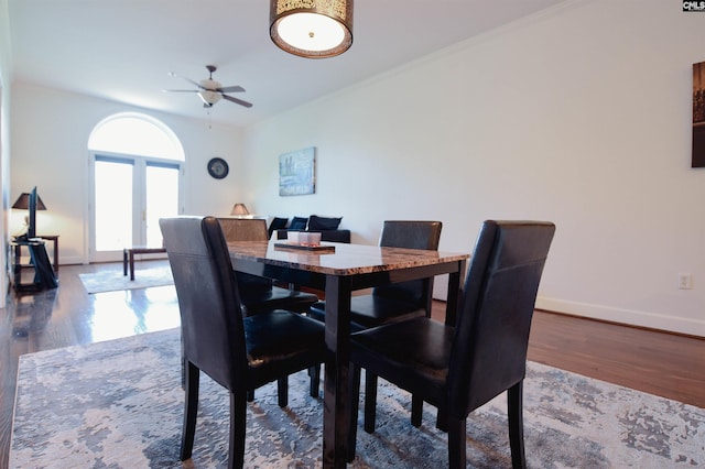 dining room featuring a ceiling fan, baseboards, and wood finished floors