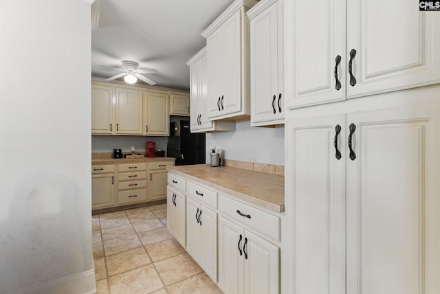 kitchen featuring freestanding refrigerator, ceiling fan, and light countertops