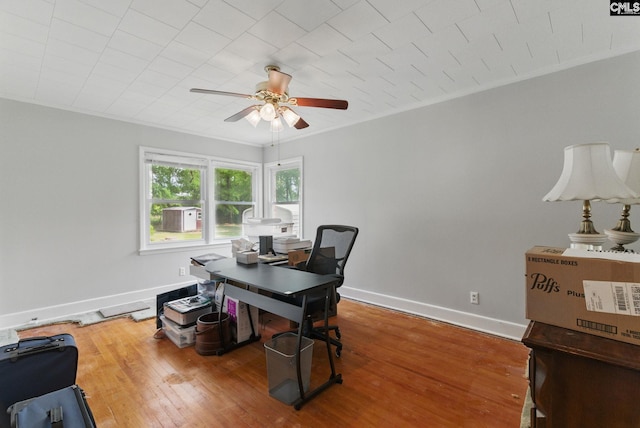 home office featuring baseboards, ornamental molding, a ceiling fan, and wood finished floors