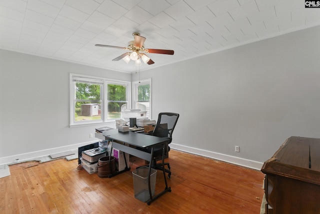 office area with baseboards, crown molding, ceiling fan, and hardwood / wood-style flooring