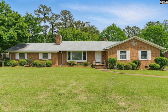 single story home with brick siding, a chimney, and a front yard