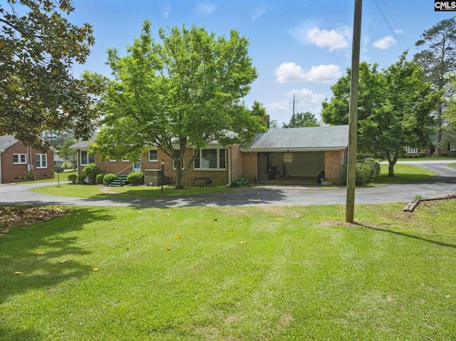 view of front of property with brick siding, driveway, and a front yard