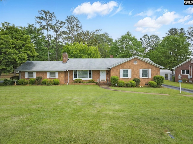 ranch-style home with brick siding, a front yard, and a chimney