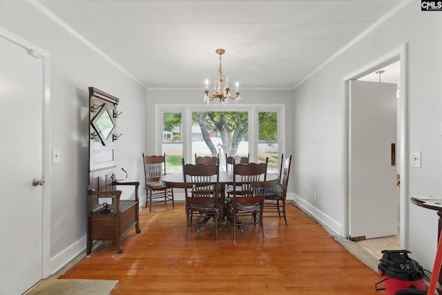dining room featuring crown molding, baseboards, an inviting chandelier, and light wood finished floors