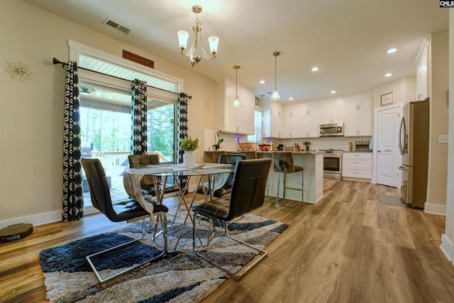 309 Creek Ridge Loop, Blythewood, SC 29016 - dining area featuring a chandelier, baseboards, visible vents, and light wood-type flooring