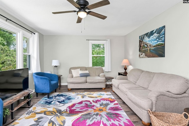 living room with baseboards, ceiling fan, and wood finished floors