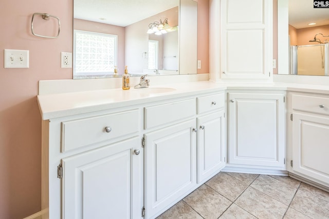 bathroom with a shower with shower door, tile patterned flooring, and vanity