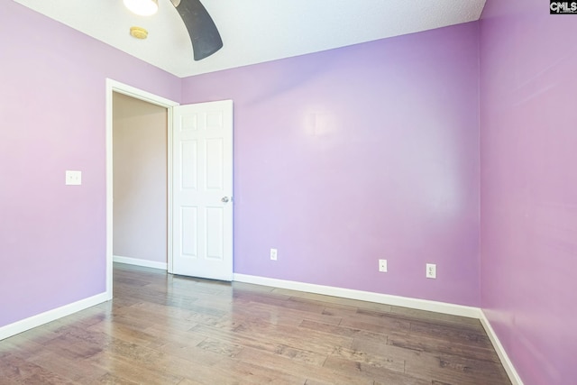 empty room featuring baseboards, a ceiling fan, and wood finished floors