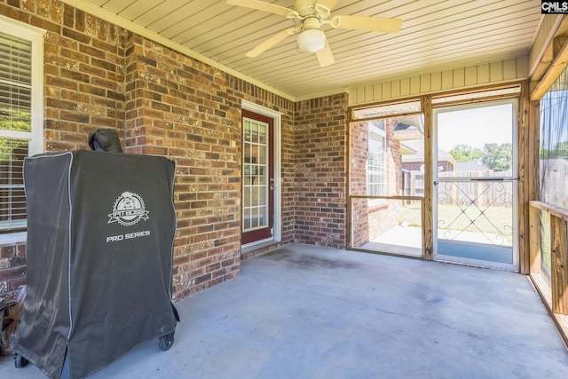 unfurnished sunroom featuring ceiling fan