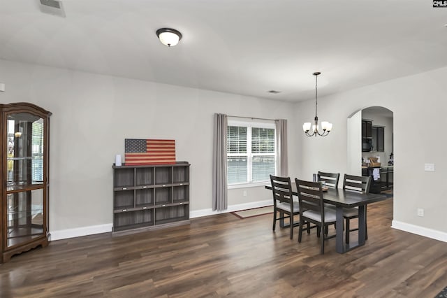 dining space with baseboards, an inviting chandelier, and wood finished floors