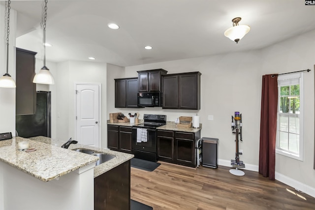 kitchen featuring a peninsula, light stone countertops, recessed lighting, a sink, and black appliances