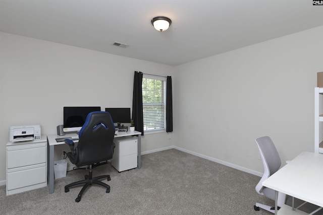 office area featuring baseboards, visible vents, and light carpet