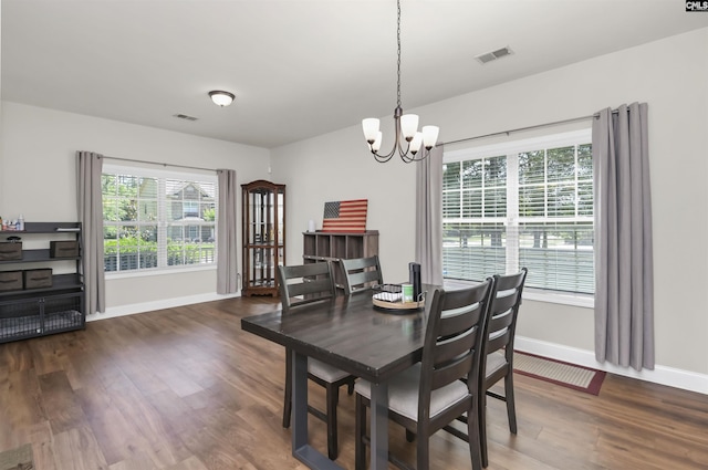 dining area featuring visible vents, baseboards, wood finished floors, and a notable chandelier