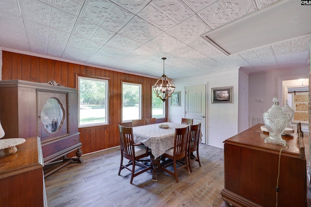 dining area featuring wood finished floors, crown molding, an ornate ceiling, and a chandelier